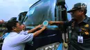 Petugas menempelkan stiker setelah mengecek kondisi bus di Pool Blue Star, Pondok Cabe, Rabu (30/5). Pengecekan ini dilakukan untuk memastikan kelayakan armada bus yang akan digunakan untuk mudik lebaran. (Merdeka.com/Arie Basuki)
