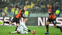 Bek Shakhtar Donetsk, Serhiy Kryvtsov (kiri) dan gelandang Olympique Lyon Houssem Aouar (tngah) berebut bola saat bermain pada penyisihan Grup F Liga Champions di Stadion NSK Olimpiyskyi, Kiev, Ukraina, Rabu (12/12). (SERGEI SUPINSKY/AFP)
