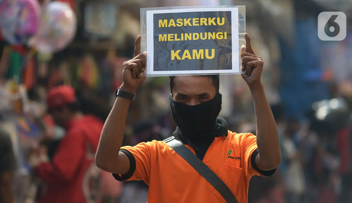 Petugas pengelola pasar melakukan kampanye dengan membawa poster kepada pedagang di Pasar Jatinegara, Jakarta, Kamis (11/6/2020). Kampanye ini sebagai bentuk kepedulian terhadap pedagang dan pembeli pasar untuk saling mengingatkan guna menekan penyebaran Corona COVID-19. (merdeka.com/Imam Buhori)