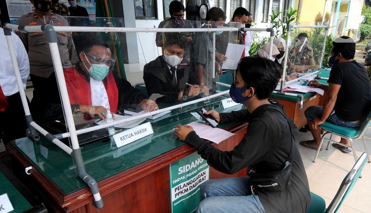 Hakim berbicara kepada pelanggar saat Sidang Tipiring pelanggaran PPKM Darurat di kantor Kecamatan Pamulang, Tangerang Selatan, Banten, Senin (19/7/2021). Dua puluh empat pelanggar diantaranya tidak bermasker dan jam operasional tempat usaha didenda. (merdeka.com/Arie Basuki)