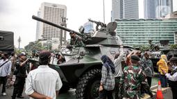 Tentara berdiri di dalam alat utama sistem senjata (alutsista) saat perayaan HUT ke-77 TNI di Bundaran HI, Jakarta, Rabu (5/10/2022). Kegiatan yang diikuti oleh seluruh kesatuan jajaran TNI ini dalam rangka menyambut HUT ke-77 TNI. (Liputan6.com/Faizal Fanani)