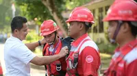 Ketua Satgas KTT AIS Forum 2023 TelkomGroup, Syaifudin secara simbolis menyematkan  perlengkapan kerja kepada perwakilan teknisi lapangan yang bertugas dalam pengawalan infrastruktur, jaringan, dan layanan TelkomGroup selama penyelenggaraan KTT, Nusa Dua Bali (6/10).