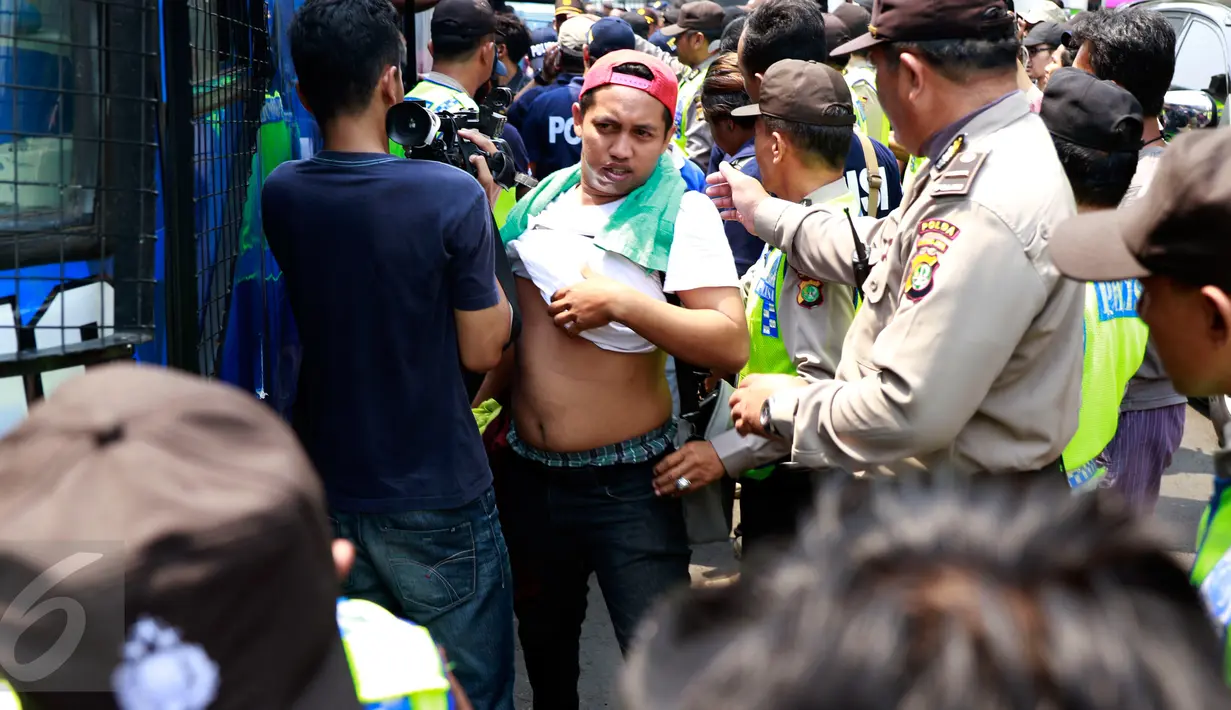 Sejumlah suporter Persib Bandung atau Bobotoh diperiksa oleh pihak kepolisian saat turun dari bis di halaman Mapolda Jakarta, Minggu (18/10/2015). Mereka nantinya akan dikawal oleh petugas kepolisian hingga Stadion GBK. (Liputan6.com/Yoppy Renato)