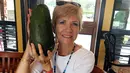 Dalam foto 28 November 2017 memperlihatkan seorang wanita Hawaii, Pamela Wang berpose dengan buah alpukat super jumbo yang ditemukannya di Kealakekua. Pamela menemukan alpukat seberat 2,3 kg yang seukuran dengan kepalanya. (AP Photo/Mary Lou Knurek)