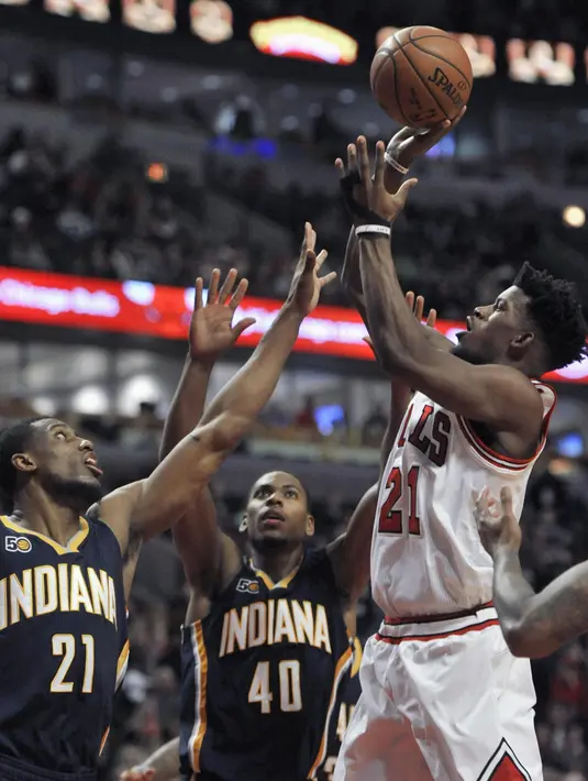 Pemain Chicago Bulls, Jimmy Butler (21) melakukan tembakan saat dihadang para pemain Indiana Pacers pada lanjutan NBA basketball game di United Center, (26/12/2016).  (AP /Paul Beaty)