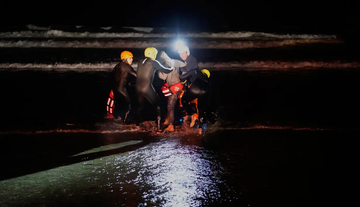 Tim penyelamat menahan seorang imigran Honduras yang berusaha menyeberangi perbatasan AS dari laut di pantai Tijuana, Meksiko, Kamis (29/11). Wali Kota Tijuana meminta bantuan PBB untuk memenuhi kebutuhan hampir 5.000 imigran. (AP Photo/Ramon Espinosa)