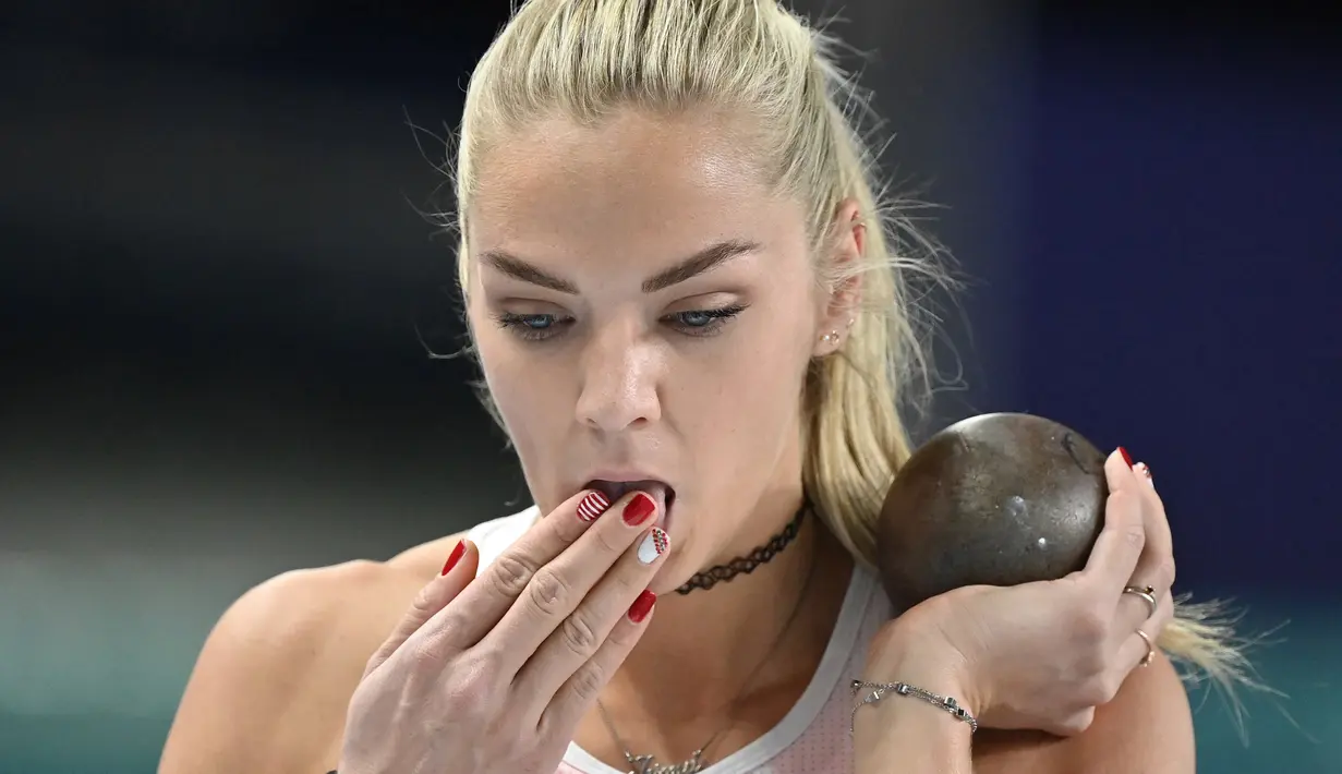 Ivona Dadic membasahkan jarinya yang dihiasi dengan cat kuku saat perlombaan tolak peluru putri dalam Kejuaraan Atletik Indoor Eropa 2021 di Torun. (Foto: AFP/Andrej Isakovic)
