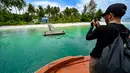 Namun, sengketa tersebut telah tuntas dengan keputusan pemerintah pusat yang menetapkan keempat pulau tersebut sebagai bagian dari wilayah administratif Provinsi Aceh. Tampak dalam foto, seorang pria mengambil foto Pulau Panjang, yang pernah menjadi objek sengketa batas pulau antara Aceh dan Sumatra Utara, di Singkil, Provinsi Aceh bagian selatan, pada Rabu 12 November 2025. (CHAIDEER MAHYUDDIN/AFP)