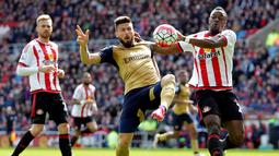 Striker Arsenal, Olivier Giroud (tengah), berebut bola dengan pemain Sunderland, Lamine Kone, dalam laga Liga Inggris di Stadium of Light, Sunderland, Minggu (24/4/2016) malam WIB. (AFP/Graham Stuart)
