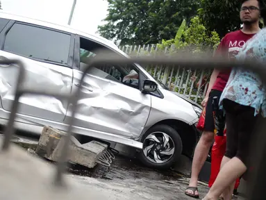 Sebuah mobil menabrak separator busway matraman arah kampung melayu, Jakarta, Sabtu (25/2). Diduga pengemudi kehilangan kendali yang akhirnya mengakibatkan menabrak separator busway. (Liputan6.com/Faizal Fanani)
