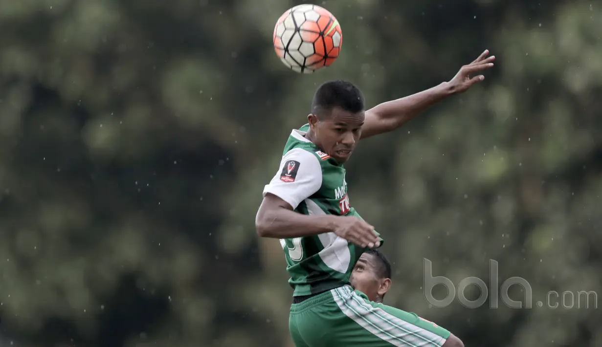 Aksi Manahati Lestusen membuang bola dari kejaran pemain Persija Jakarta, Ramdani Lestaluhu pada laga uji coba di GOR Ahmad Yani, Cilangkap, Minggu (9/4/2017). PS TNI bermain imbang lawan Persija. (Bola.com/Nicklas Hanoatubun)