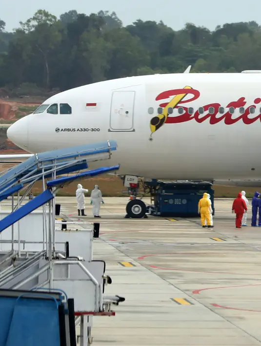 <p>Sejumlah Warga Negara Indonesia (WNI) yang dievakuasi dari Wuhan, China keluar dari pesawat Batik Air Airbus 330-300CEO di bandara internasional Hang Nadim, Batam, Minggu (2/2/2020). Para WNI langsung ke luar pesawat untuk selanjutnya menuju Natuna, Kepulauan Riau. (AFP/Ricky Prakoso)</p>