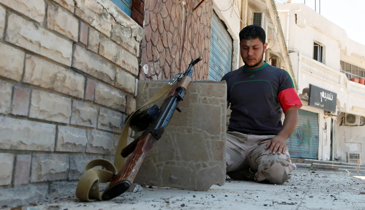 Seorang anggota pasukan Libya menunaikan salat sebelum dirinya dan rekan-rekannya berperang melawan militan ISIS di Sirte, Libya (29/8). Ditengah kecamuknya perang militer libya tetap menunaikan kewajiban salat. (REUTERS/Ismail Zitouni)