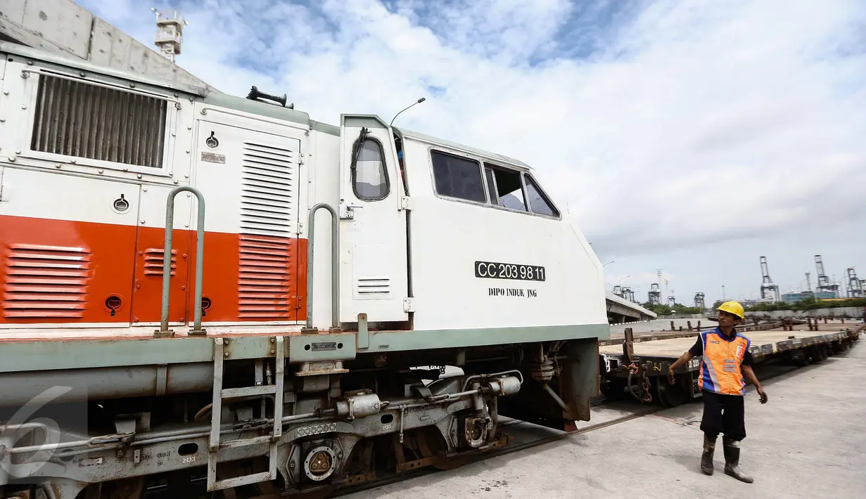 Petugas mengecek gerbong peti kemas di jalur kereta api Stasiun JICT Tanjung Priok yang terletak di samping gate in-out bersama (gate gallery) terminal peti kemas JICT-TPK Koja, Jakarta, Jumat (13/1). (Liputan6.com/Faizal Fanani)