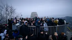 Orang-orang berkumpul di sudut pandang yang menghadap ke cakrawala kota untuk menyaksikan matahari terbit pertama tahun baru, meskipun dalam kondisi mendung, di Seoul, Korea Selatan (1/1/2020). (AFP/Ed Jones)