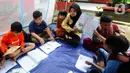 Guru mengajari murid-murid korban gempa belajar di dalam tenda darurat yang dibangun di halaman sekolah di SDN Gintung, Mangunkerta, Cianjur, Jumat (23/12/2022). Lebih dari sebulan sejak musibah gempa bumi 5,2 SR sejumlah murid sekolah di Cianjur masih belajar pada tenda darurat. (merdeka.com/Arie Basuki)