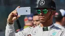 Pembalap F1 dari tim  Mercedes, Lewis Hamilton berselfie saat Formula One Grand Prix di Melbourne, Australia (20/3/16). Lewis Hamilton memiliki 2 juta followers di media sosial Instagram dengan 1887 foto. (REUTERS/Brandon Malone)