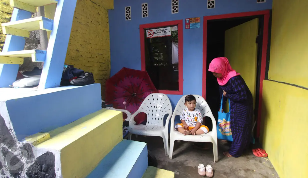 Salah satu warga yang tinggal di Kampung Penas Tanggul, Cipinang Besar Selatan, Jakarta, Kamis (23/3). Kampung warna-warni tanpa rokok tersebut dibuat oleh warga sebagai bentuk upaya perlindungan bagi perempuan dan anak. (Liputan6.com/Immanuel Antonius)