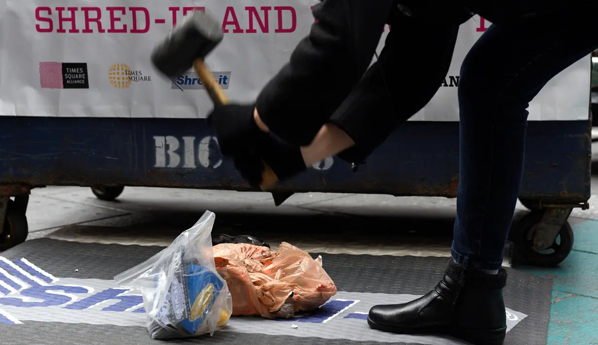 Seorang warga menghancurkan komponen komputer menggunakan palu dalam acara "Good Riddance Day" di Times Square, New York, Rabu (28/12). Orang-orang berkumpul untuk membuang benda-benda yang ingin mereka lupakan di tahun yang baru. (REUTERS/Darren Ornitz)