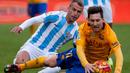 Pemain Barcelona, Lionel Messi (kanan), dijatuhkan pemain Malaga, Duda, dalam laga La Liga Spanyol di Stadion La Rosaleda, Malaga, Sabtu (23/1/2016). (AFP/Jorge Guerrero)