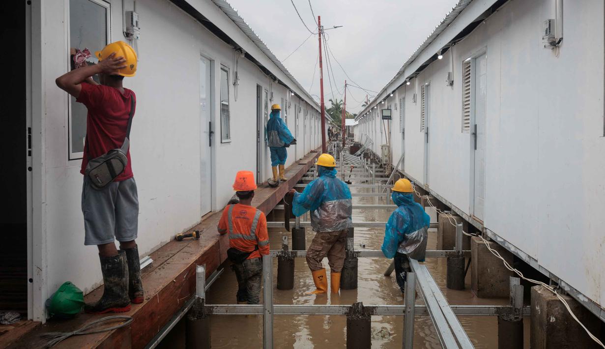 Aktivitas pekerja menyelesaikan pembangunan hunian sementara untuk warga korban banjir bandang dan tanah longsor di di Aceh Tamiang, provinsi Aceh, pada Kamis 8 Januari 2026. Menggandeng PT PP (Persero) Tbk (PTPP), Badan Pengelola Investasi (BPI) strategis Indonesia, atau dikenal sebagai Daya Anagata Nusantara (Danantara) membangun hunian sementara tanggap darurat bagi warga terdampak banjir. (ADITYA AJI/AFP)
