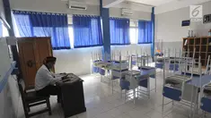 Seorang guru beraktivitas di ruang kelas yang kosong di Mts Annajah, Petukangan, Jakarta Selatan, Senin (5/8/2019). Masih padamnya listrik di sejumlah kawasan Jakarta membuat kegiatan belajar mengajar terganggu hingga memaksa pihak sekolah memulangkan siswa lebih awal. (merdeka.com/Arie Basuki)