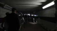Orang-orang berjalan di kegelapan Stasiun Clapham Junction saat pemadaman listrik, di London pada 9 Agustus 2019. (AP)