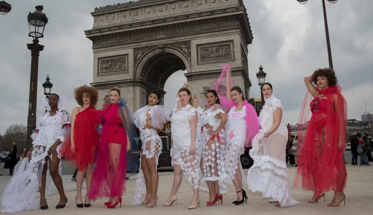 Sejumlah wanita yang tergabung dalam plus size models atau model ukuran plus berpose di depan Triump Arch di Paris, Prancis (4/1). Meraka melakukan catwalk di ruang publik dengan mengenakan busana layaknya di sebuah acara fashion show. (AFP/Thomas Samson)