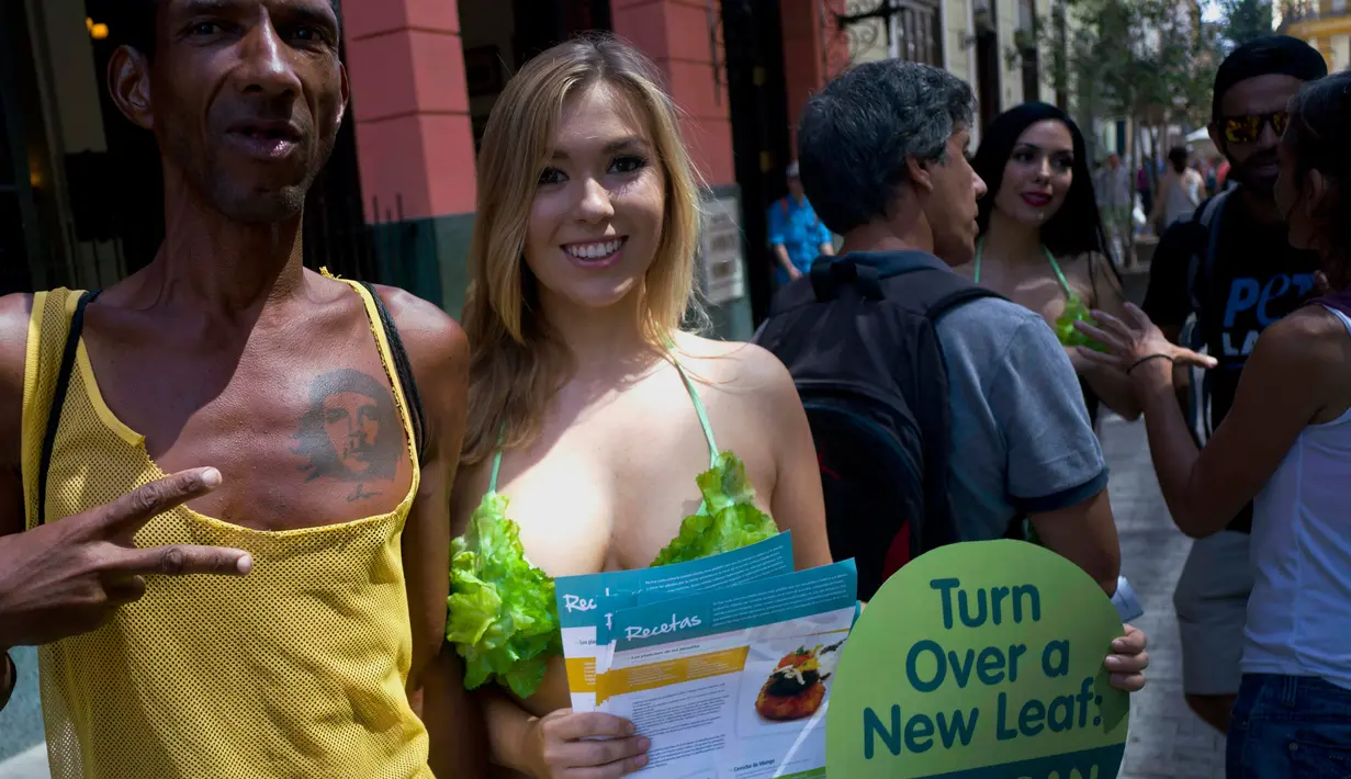Aktivis Ethical Treatment of Animals (PETA) berpose bersama warga saat berkampanye di jalanan Havana, Kuba, Kamis (2/3). Mereka mengajak masyarakat untuk beralih dengan gaya hidup vegetarian. (AP Photo/ Ramon Espinosa)