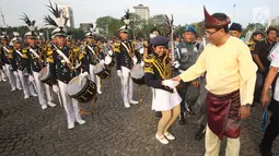 Menhub Budi Karya Sumadi menyapa salah satu pemain marching band pada acara puncak Hari Perhubungan Nasional di Lapangan Silang Monas, Jakarta, Minggu (17/9). Menhub Budi menggunakan baju khas daerahnya Palembang. (Liputan6.com/Immanuel Antonius)