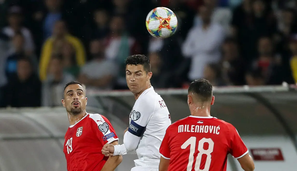 Striker Portugal, Cristiano Ronaldo, duel udara dengan bek Serbia, Nikola Maksimovic, pada laga Kualifikasi Piala Eropa 2020 di Belgrade, Sabtu (7/9). Serbia kalah 2-4 dari Portugal. (AFP/Pedja Milosavljevic)