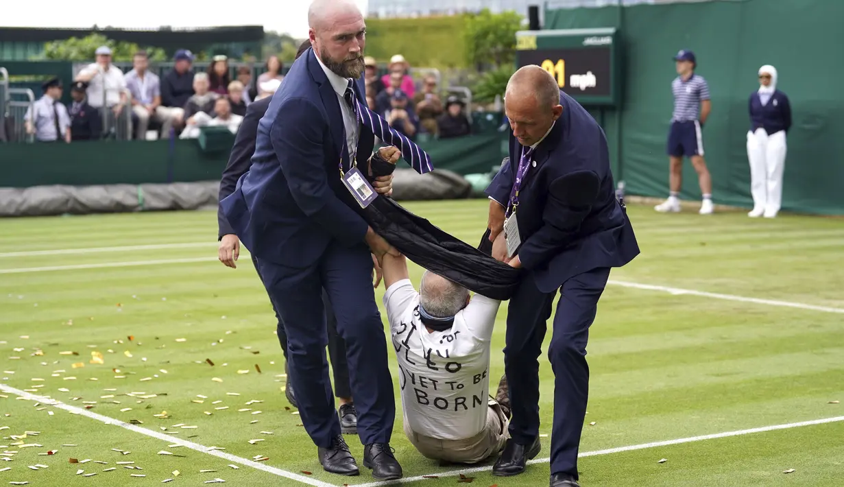 Seorang pria memasuki lapangan dan melemparkan confetti berwarna oranye serta potongan-potongan puzzle hanya beberapa jam setelah insiden pertama. (Adam Davy/PA via AP)