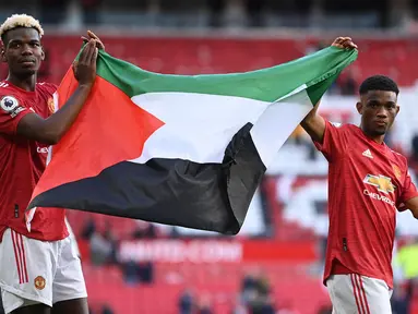 Paul Pogba dan Amad Diallo pun menjadi pesepakbola profesional yang mengekspresikan solidaritas mereka untuk rakyat Palestina. Keduanya memang merupakan pemain Muslim di skuad United. (Foto: AFP/Pool/Laurence Griffiths)