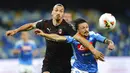 Striker AC Milan, Zlatan Ibrahimovic, berebut bola dengan  pemain Napoli, Mario Rui, pada laga Serie A di Stadion San Paolo, Minggu, (12/7/2020). Kedua tim bermain imbang 2-2. (Spada/LaPresse via AP)