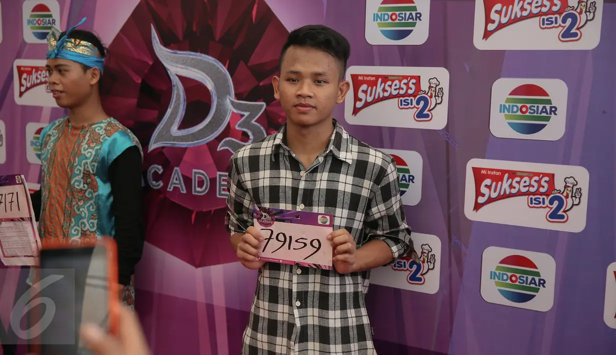 Peserta berfoto dibelakang backdroop D Academy  saat Audisi D Academy 3 Indosiar di Jakarta, Minggu (6/12). Tak hanya dari Jakarta, peserta juga berasal dari berbagai daerah seperti Papua dan beberapa kota di Sumatera. (Liputan6.com/Faizal Fanani)