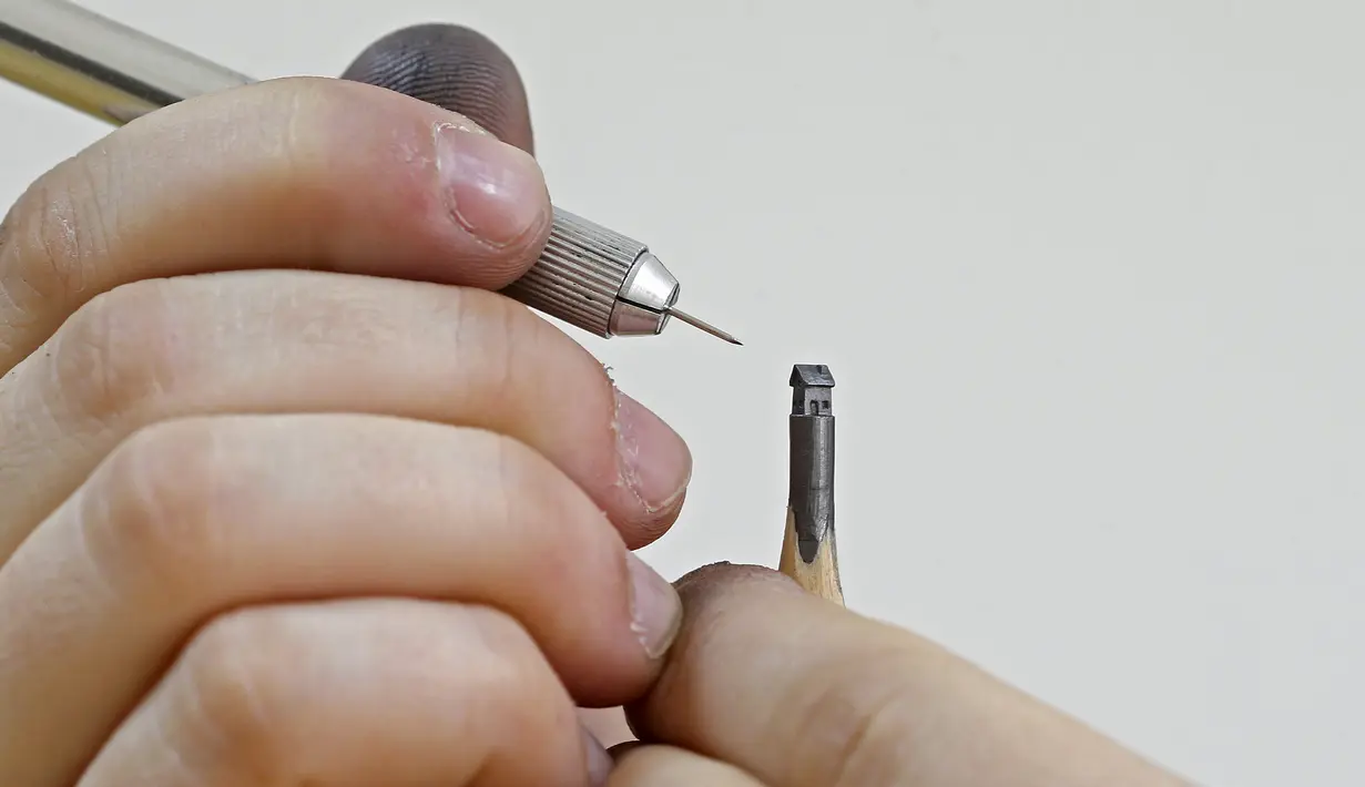Jasenko Djordjevic saat mengukir ujung pensil menjadi sebuah rumah di Tuzla, Bosnia dan Herzegovina, Selasa (26/4). Keterampilan Djordjevic membutuhkan konsentrasi penuh saat membuat ukiran miniatur. (REUTERS / Dado Ruvic)