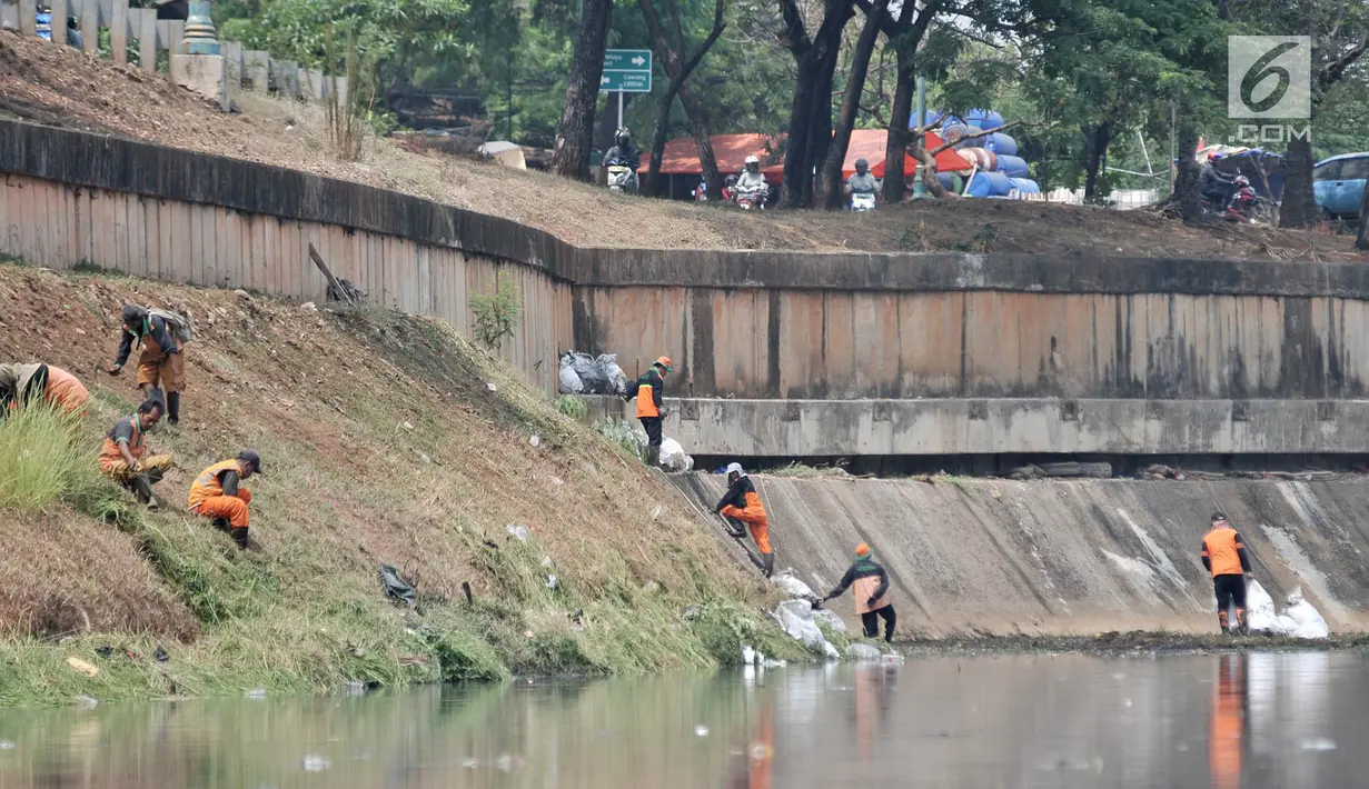 Petugas PPSU dan Sudin Tata Air Jakarta Timur membersihkan sampah dan tanaman liar di sepanjang aliran Kanal Banjir Timur (KBT), Senin (15/10). Banyak sampah yang bermunculan ke permukaan akibat debit air surut. (Merdeka.com/ Iqbal S. Nugroho)