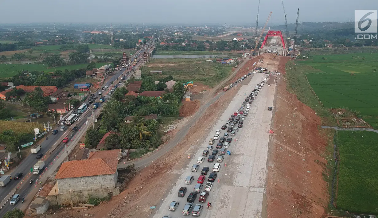 Foto udara kepadatan pemudik untuk keluar dari ruas Tol Batang-Semarang menuju jalur Pantura Batang-Kendal di Kali Kuto, Gringsing, Kabupaten Batang, Jawa Tengah, Senin (11/6). (Liputan6.com/Arya Manggala)