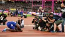 Sejumlah fotografer mengabadikan atlet asal Amerika Serikat, Justin Gatlin setelah memenangi final acara atletik 100m putra di Kejuaraan Dunia IAAF 2017 di Stadion London di London, Inggris (5/8). (AFP Photo/Ben Stansall)