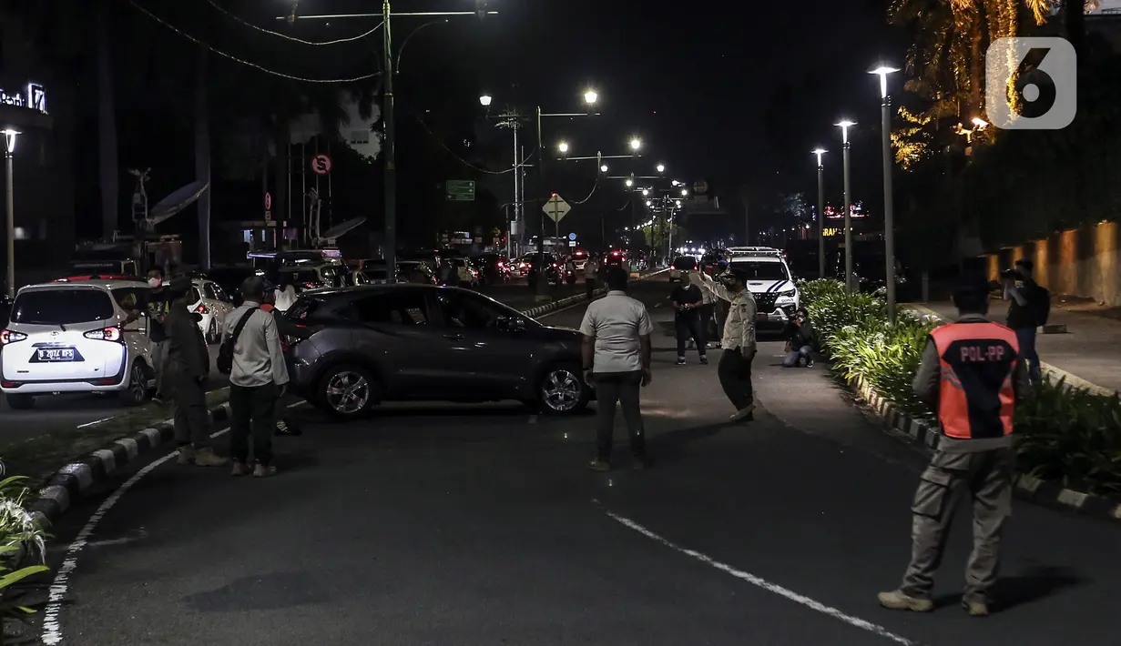 Petugas gabungan berjaga saat berlangsungnya Crowd Free Night di kawasan Bundaran HI, Jakarta, Jumat (31/12/2021). Polda Metro Jaya memberlakukan pengendalian mobilitas Crowd Free Night pada malam Tahun Baru 2022 yang berlangsung mulai pukul 22.00-04.00 WIB. (Liputan6.com/Johan Tallo)