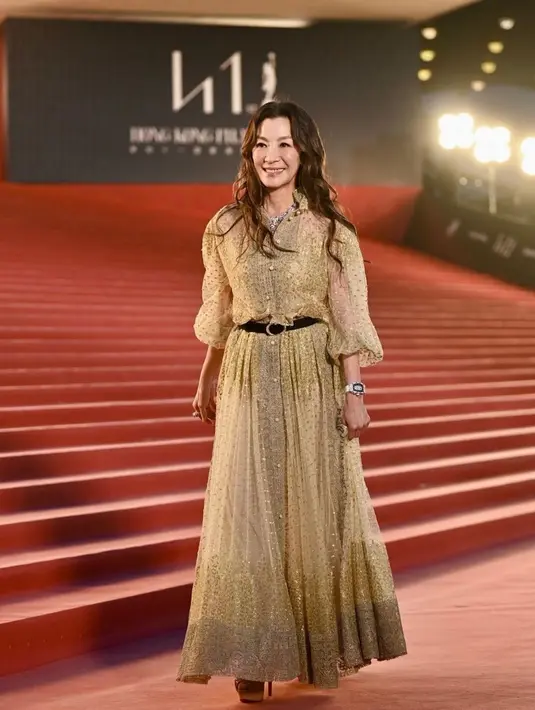Michelle Yeoh tampil glamor dengan busana yang merupakan garapan desainer ternama, Dior. Gaun emas dengan aksen puffy sleeve itu merupakan karya dari Maria Grazia Chiuri [@michelleyeoh_official]