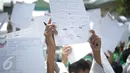 Murid MI Yayasan Nurul Bahri menunjukkan surat yang ditulis untuk Presiden Jokowi, di perkampungan nelayan Muara Angke, Jakarta, Senin (27/2). Kegiatan itu juga sebagai kepedulian pada dunia literasi untuk anak Indonesia. (Liputan6.com/Faizal Fanani)