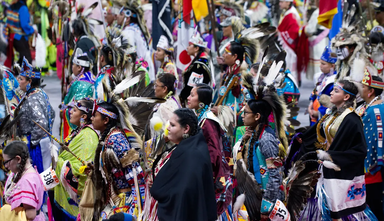 Para penari asli Amerika ikut berpartisipasi dalam Grand Entry of the Denver March Powwow di Denver, Colorado (24/3). Sejak 2009 acara ini diikuti dari berbagai suku asli Amerika, 35 negara bagian AS, dan lima provinsi Kanada. (AFP/Jason Connolly)