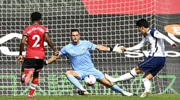 Penyerang Tottenham Hotspur, Son Heung-min, mencetak gol ke gawang Southampton pada laga Liga Inggris di Stadion St. Mary's, Minggu, (20/9/2020). Tottenham menang dengan skor 5-2. (Justin Tallis/Pool via AP)
