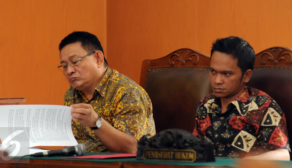 Tim kuasa hukum Kejaksaan Agung, Rhein Singal (kiri) membaca berkas pengajuan praperadilan dari tim kuasa hukum inovator mobil listrik Dasep Ahmadi di PN Jaksel, Senin (26/10/2015). Sidang akan dilanjutkan Selasa (27/10). (Liputan6.com/Helmi Fithriansyah)