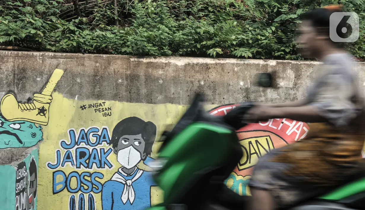 Pengendara motor melintasi mural bertema imbauan protokol kesehatan COVID-19 di kawasan Cakung Barat, Jakarta, Minggu (18/10/2020). Mural karya warga setempat tersebut bertujuan mengingatkan masyarakat akan pentingnya memakai masker, menjaga jarak, dan mencuci tangan. (merdeka.com/Iqbal S. Nugroho)