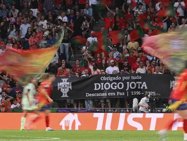 Penggemar Portugal memberikan penghormatan kepada penyerang Liverpool asal Portugal, Diogo Jota yang meninggal dunia akibat kecelakaan mobil di Spanyol, selama pertandingan sepak bola Women's Euro 2025 Grup B di stadion Wankdorf, Bern, Jerman pada 3 Juli 2025. (SEBASTIEN BOZON/AFP)