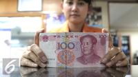 Seorang teller menunjukan mata uang Yuan di Jakarta, Senin (30/11). Dana Moneter Internasional (IMF), Senin (30/11), resmi memasukan yuan, atau renminbi, ke dalam special drawing rights (SDR) sebagai mata uang elite dunia. (Liputan6.com/Angga Yuniar)