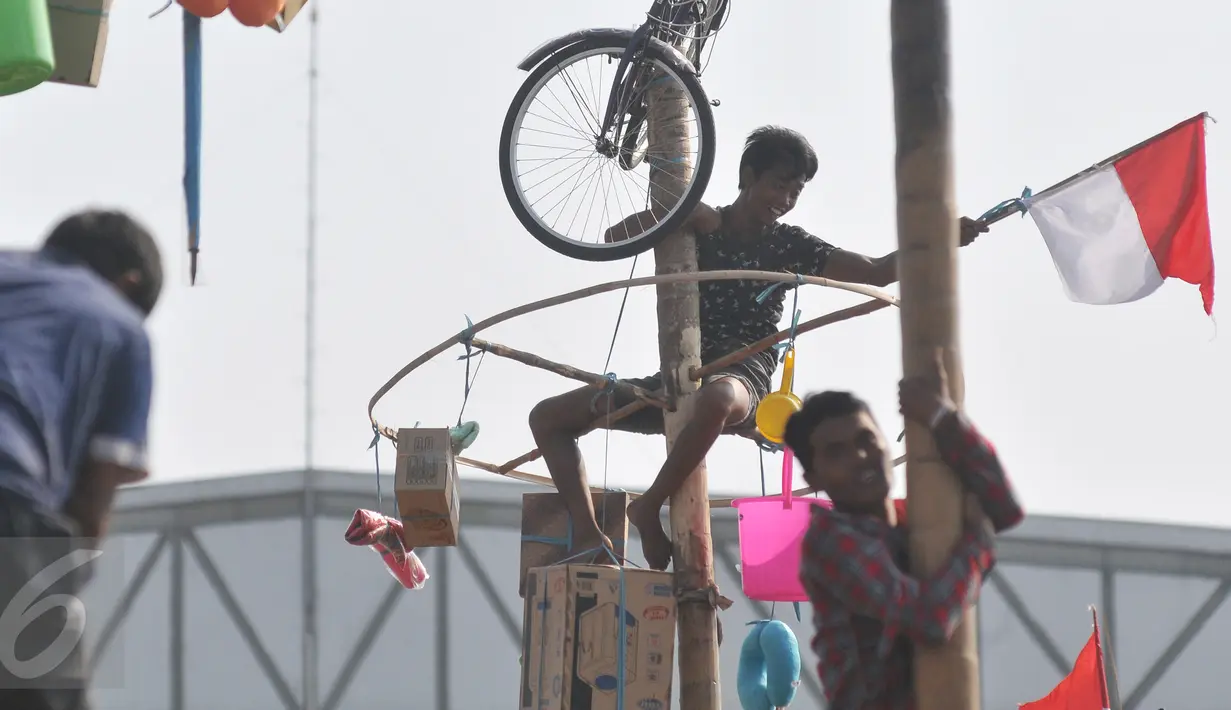 Warga mengikuti lomba Panjat Pinang Kolosal dalam rangka merayakan HUT RI ke-70 di Pantai Karnaval, Ancol, Jakarta, Senin (17/8). Sebanyak 124 batang pinang disediakan dengan berbagai ragam hadiah. (Liputan6.com/Herman Zakharia)