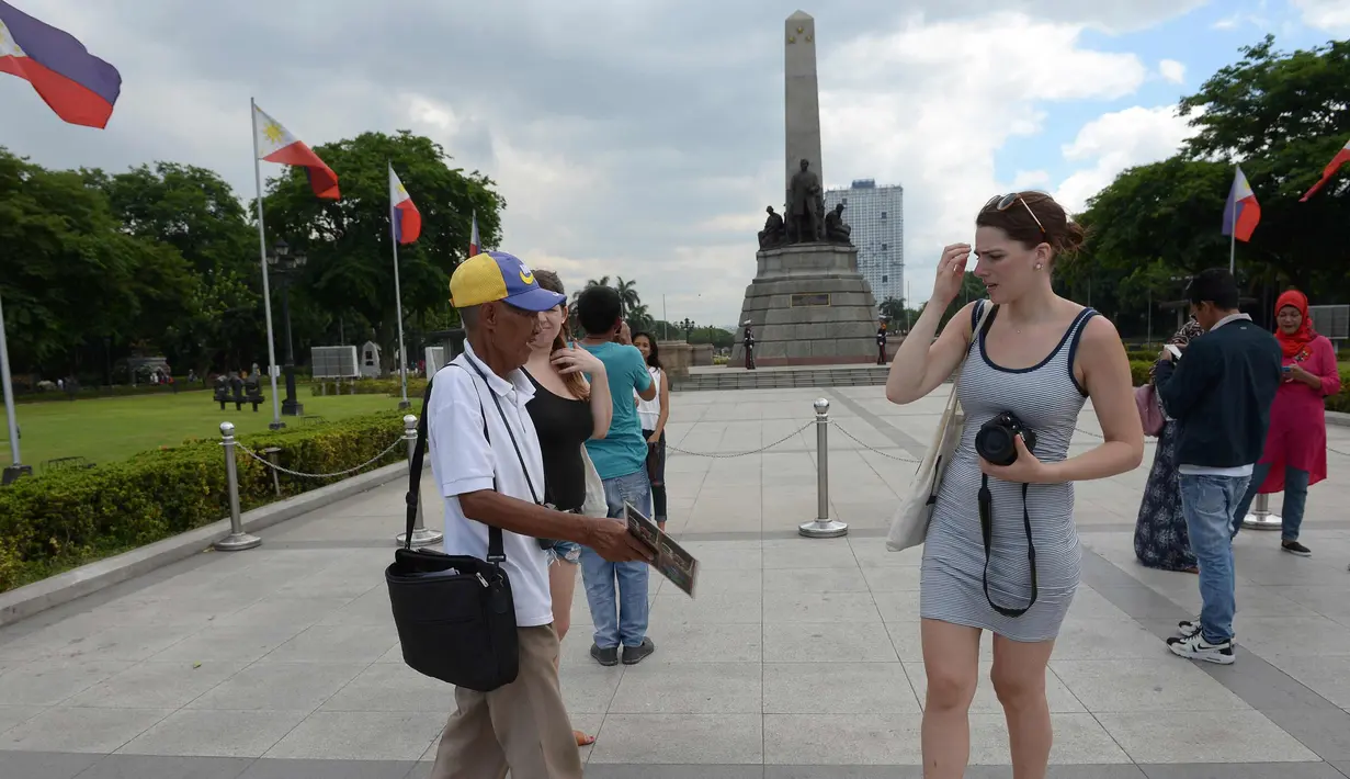 Joel Estrella menawarkan jasa foto kepada wisatawan di sebuah taman di Manila, (22/4). Estrella melihat penurunan pelanggan sejak munculnya ponsel kamera yang memotong penghasilannya ketika ia mulai sebagai fotografer muda. (AFP Photo/Ted Aljibe)
